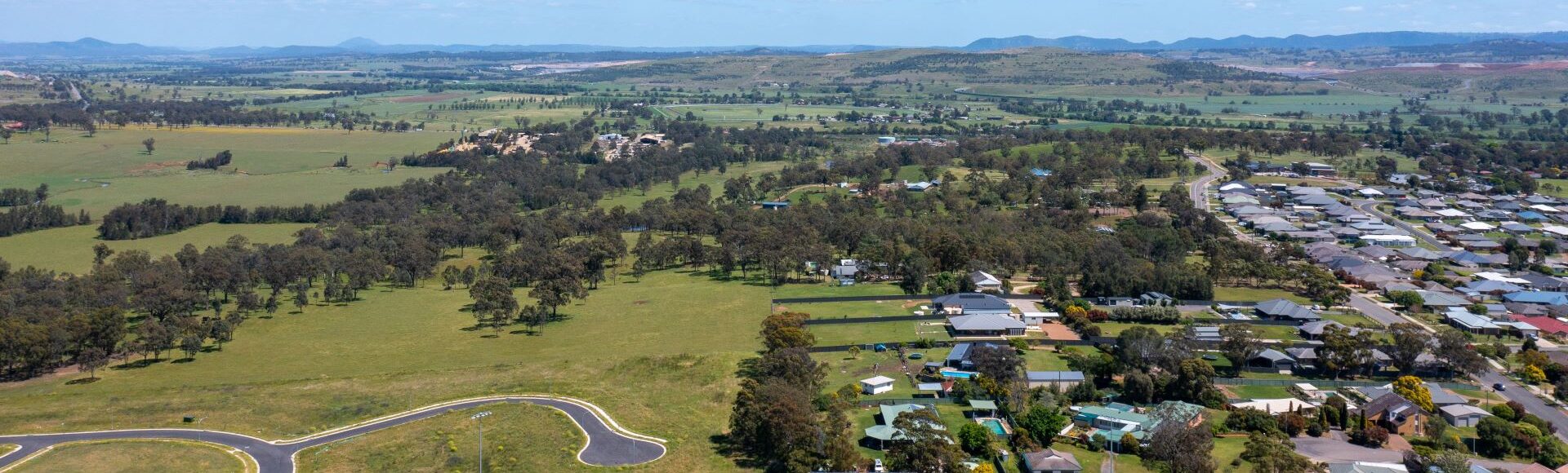 Aerial view of Muswellbrook, featuring residential houses and undeveloped land.